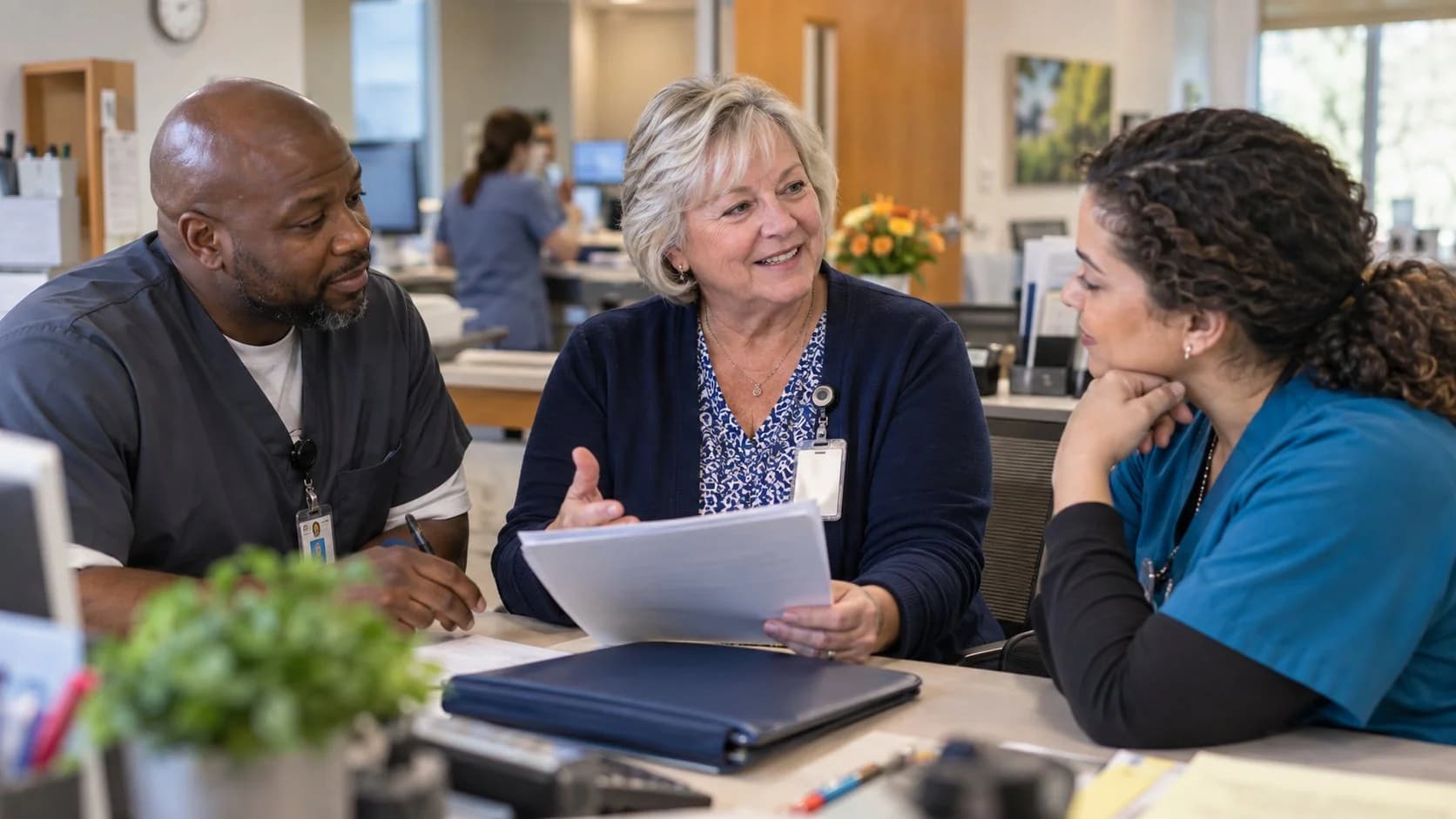 Revenue-cycle educator discussing a workflow with medical-office colleagues