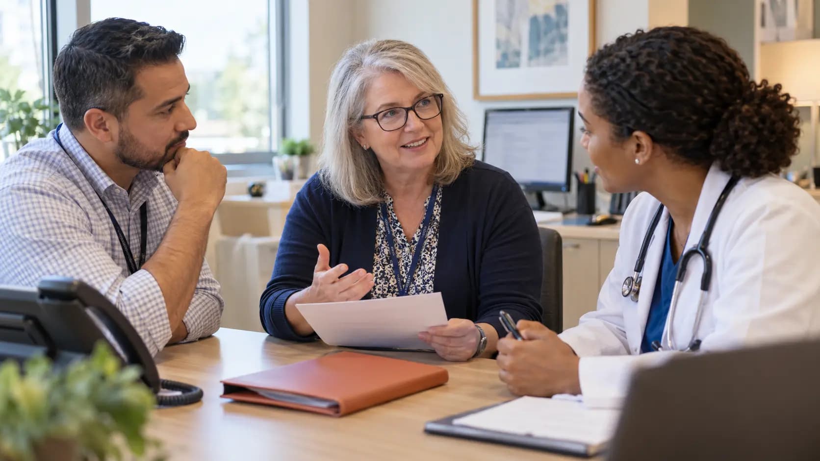 Practice manager and clinician reviewing payer requirements with a specialist