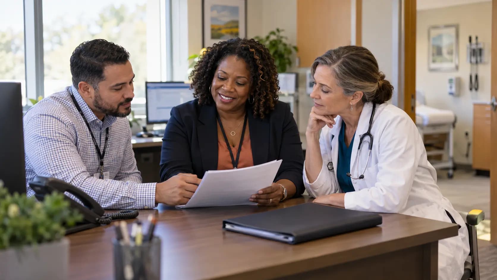 Practice manager and clinician reviewing payer requirements with a specialist
